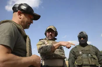  ?? Michal Dyjuk, The Associated Press ?? Belarus regiment leader Vadim Prokopiev, left; Polish instructor Dariusz Tomysek, center, and a volunteer from Belarus speak during a training session at a shooting range near Warsaw, Poland, on Friday.