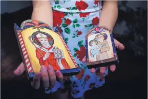  ?? ROBERTO E. ROSALES/JOURNAL ?? Spanish Market artist Skyler Valdez holds two retablos. On the left is San Nicolas, and on the right is St. Anthony of Padua.