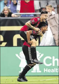  ??  ?? Hector Villalba rides on midfielder Yamil Asad’s back as he celebrates his first-half goal Saturday night. Villalba’s sixth goal of the season came after Asad’s eighth assist.