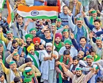  ?? — PTI ?? Farmers celebrate after the decision to withdraw from borders of the national capital in the wake of the government accepting all demands put forward by them, at Ghazipur border in Ghaziabad on Thursday.