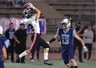  ??  ?? (Left) Hart’s Angelo Lucchese Makes a catch against Saugus’ Jakob Corrigan (13) in the first quarter at COC on Friday.