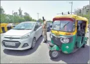  ?? SUNIL GHOSH/HT ?? A police officer screens commuters at the Delhi-noida border, a day before the Capital expands its unlock process.