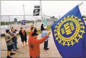  ?? Jeff Kowalsky AFP/Getty Images ?? STRIKING workers picket outside the General Motors assembly plant last month in Flint, Mich.