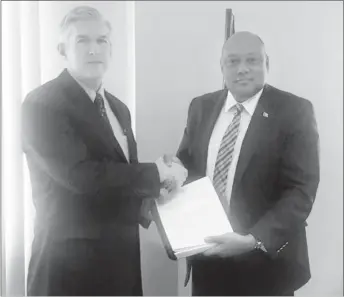  ?? (Ministry of Natural Resources photo) ?? ExxonMobil Country Manager Rod Henson (left) and Minister of Natural Resources Raphael Trotman with the production licence on June 15 this year.