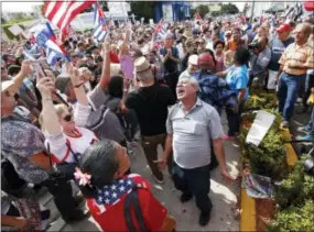  ?? THE ASSOCIATED PRESS ?? Members of the Cuban community react to the death of Fidel Castro on Saturday in the Little Havana area in Miami. Castro, who led a rebel army to improbable victory in Cuba, embraced Soviet-style communism and defied the power of 10 U.S. presidents...