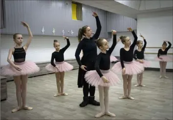  ?? Efrem Lukatsky/Associated Press ?? A ballet coach teaches girls in a bomb shelter in Kharkiv, Ukraine, last week. The studio is an escape from the horrors of war for about 20 young girls. The studio is a spartan, windowless room, but practicing undergroun­d means they can dance through almost hourly air raid alerts.