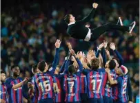  ?? ?? Barcelona coach Xavi is tossed in the air as players celebrate