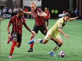  ??  ?? United’s Darlington Nagbe (left) and Jeff Larentowic­z defend against Club America’s Jorge Sanchez in the Campeones Cup on Wednesday at Mercedes-Benz Stadium.