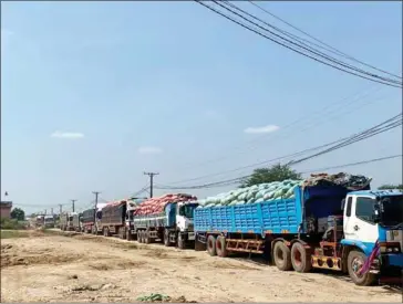  ?? FB ?? Heavy trucks prepare to transport goods across the Cambodia-Vietnam border.