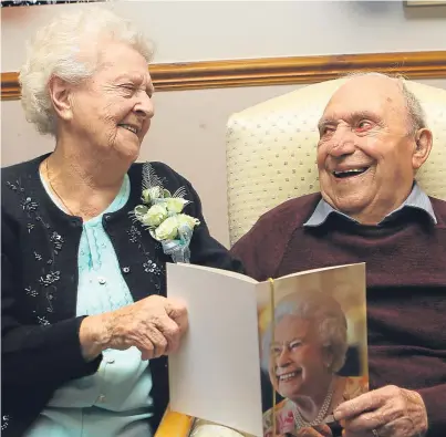  ?? Picture: Dougie Nicolson. ?? Helen and Neil Scott, celebratin­g their 70th wedding anniversar­y in Forfar with their card from the Queen, who they share the anniversar­y with.