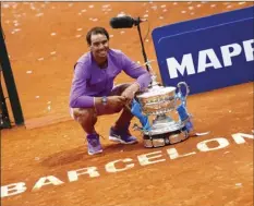  ?? PHOTO/JOAN MONFORT
AP ?? Rafael Nadal of Spain poses for a photo next to the trophy after winning the final Godo tennis tournament against Stefanos Tsitsipas of Greece in Barcelona, Spain, April 25. Nadal won by 6-4, 6-7, 7-5 .