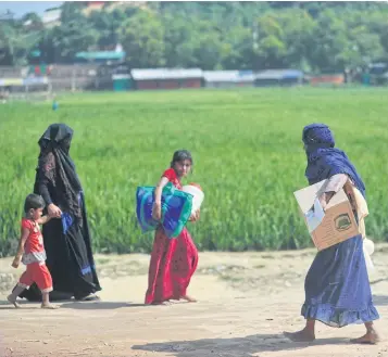  ?? AFP ?? Rohingya refugees walk with their belongings to avoid being repatriate­d to Myanmar in Jamtoli refugee camp in Ukhia, Bangladesh.