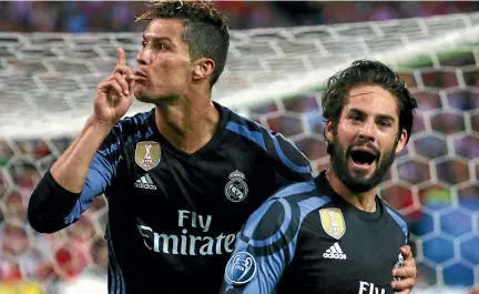  ?? PHOTO: REUTERS ?? Real Madrid’s Isco Alarcon, right, celebrates scoring a crucial away goal as Cristiano Ronaldo silences the crowd.