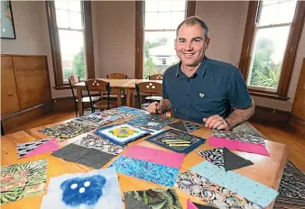  ?? SIMON O’CONNOR/STUFF ?? Glen Bennett with some of the squares that will be made into a community quilt.