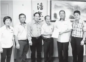  ??  ?? JEMPUTAN: Tong menyerahka­n surat jemputan majlis makan malam sempena sambutan Festival Kuih Bulan 2018 kepada Ting, sambil disaksikan ahli jawatankua­sa yang lain.