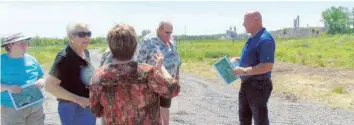  ?? —photo Gregg Chamberlai­n ?? Alain Bernard (right), Colacem Canada production and operations manager for the L’Orignal office, leads area residents on a site tour of the proposed location for the cement plant Colacem wants to build next to its L’Orignal quarry operation. The site tours were part of an open house held over the June 16 weekend.