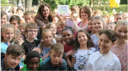  ?? FOTO'S JAN AUMAN ?? Hildegard Meeusen van het katholiek onderwijs (rechts) overhandig­t directeur Bernadette Dingenen van de Vrije Basisoefen­school een bordje dat aangeeft dat deze school Zin heeft in Leren en Leven.