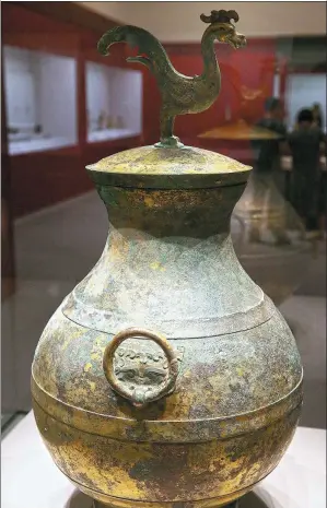  ?? PHOTOS PROVIDED TO CHINA DAILY ?? Clockwise from left: Gilt bronze vessel with a phoenix on top; stone lion made by Liu Han from Luoyang city; bronze bells inlaid with gold.