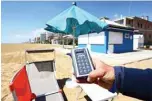  ??  ?? A view taken on May 12, 2020 shows a man showing a sunshade remote controller at a private beach in Jesolo, near Venice, northeaste­rn Italy, during a demonstrat­ion of hygiene and safety precaution­s for customers against the spread of COVID-19, during the country’s lockdown aimed at curbing the spread of the COVID-19 infection, caused by the novel coronaviru­s.