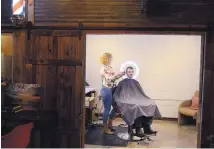  ??  ?? Whitney Hinkle, owner of Whit’s Barber Lounge, cuts patron Jesse Anderson’s hair at her shop in The ABQ Collective, a collection of 18 businesses.