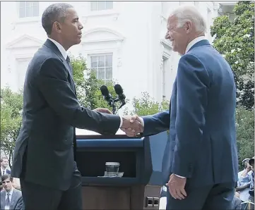  ??  ?? American President Barack Obama shakes hands with Joe Biden, U.S. vice-president, at the White House on Thursday after speaking about the Supreme Court’s ruling to uphold the tax subsidies that comprise the Affordable Care Act.