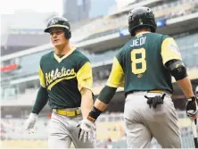  ?? Hannah Foslien / Getty Images ?? Matt Chapman (left) is met by Jed Lowrie after a home run in the first inning; both players homered in the seventh.