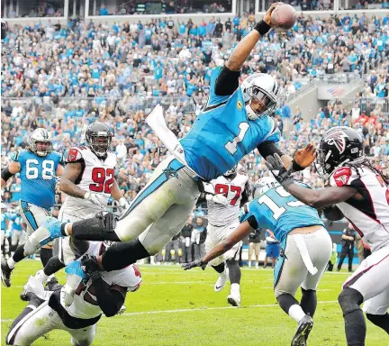  ?? GRANT HALVERSON/GETTY IMAGES ?? Carolina Panthers quarterbac­k Cam Newton dives into the end zone for a touchdown during the second quarter against the Atlanta Falcons on Sunday in Charlotte, N.C. Newton led the Panthers’ rushing attack with 86 yards as Carolina won 20-17.