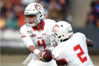  ?? AP Photo/Andres Leighton, File ?? ■ Houston Baptist running back Ean Beek (2) takes a hand-off from quarterbac­k Bailey Zappe (4) during the first half against UTEP on Aug. 31, 2019, in El Paso, Texas. Houston Baptist still had three games scheduled for its eighth football season when its FCS Southland Conference decided only a few weeks ago to not play league games this fall. Even with expanded protocols and more costly virus testing, the Huskies are moving forward with their remaining games.