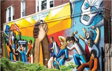  ?? ASHLEE REZIN GARCIA/SUN-TIMES ?? Another Humboldt Park mural, this one from John Pitman Weber, was done in 1971 and called “Unidos para Triunfar,” or “Together We Overcome.” It was intended to promote unity and settle racial tensions in the area. Located at Division Street and Hoyne Avenue, it’s one of the oldest surviving murals in the city.