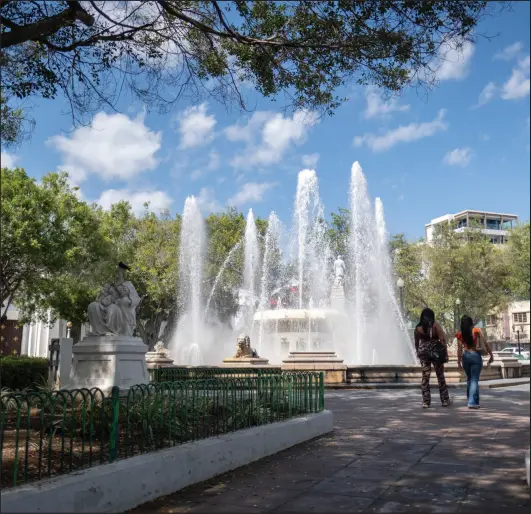  ?? Photo by Ricardo Arduengo for The Washington Post ?? People walk on the public square next to a water fountain in Ponce, Puerto Rico on March 28, 2024.