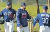  ?? Ross D. Franklin Associated Press ?? ADRIAN GONZALEZ, with Adam Liberatore (36) and Manager Dave Roberts, is sidelined in camp.