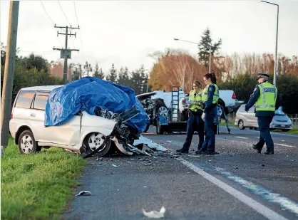  ?? PHOTOS: DAVID WALKER/FAIRFAX NZ ?? Police on the scene where a southbound stationwag­on and northbound ute towing a trailer collided on State Highway 1 near Woodend yesterday afternoon resulting in the deaths of two young men and injuring two others.
