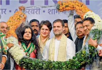  ?? —PTI ?? Congress leader Rahul Gandhi and party General Secretary Priyanka Gandhi Vadra being garlanded during an election campaign rally in support of party candidate from Sangam Vihar constituen­cy Poonam Azad, ahead of the State Assembly polls at Sangam Vihar in New Delhi on Tuesday.