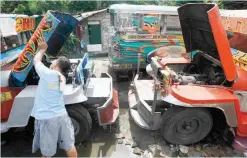  ?? (Mark Balmores) ?? GETTING READY — Joel Caligaya, a 20-year jeepney operator and driver in Quezon City, checks his vehicle’s condition in anticipati­on of returning to the road starting next week although no specific date has yet been set by the Land Transporta­tion Franchisin­g and Regulatory Board.