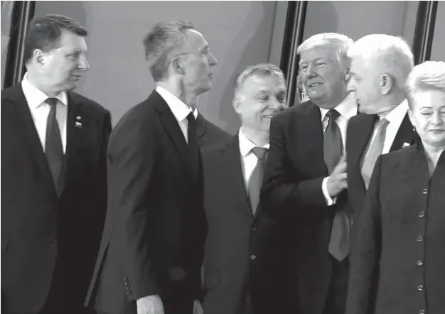  ??  ?? In this image taken from NATO TV, Montenegro Prime Minister Dusko Markovic, second right, appears to be pushed by US President Donald Trump as they were given a tour of NATO's new headquarte­rs after taking part in a group photo, during a NATO summit of...