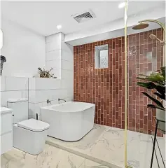  ??  ?? This bathroom, left, in the multi-award-winning Cantilever House by Redmond Builders, features travertine tiles and a large tub. Right, Amy Moore and Stu Watts’ bathroom in the fifth apartment on The Block NZ is the only one to use colour to make a bold statement.