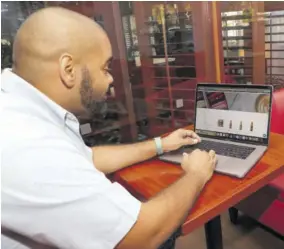  ??  ?? Caribshopp­er Chief Executive Offcier Kadion Preston looking at some of the Caribbean products offered on the company’s website.