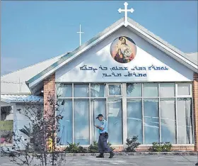  ?? EFE ?? Sidney. Un policía pasa cerca a la iglesia ortodoxa asiria del Buen Pastor.