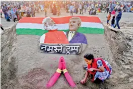  ?? — PTI ?? Sand artist Laxmi Gaud creates a sculpture of Prime Minister Narendra Modi and US President Donald Trump on the eve of latter’s maiden visit to India, at Juhu Beach in Mumbai on Sunday