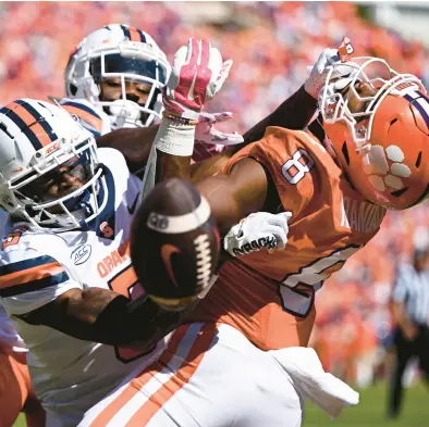  ?? EAKIN HOWARD/GETTY ?? Syracuse’s Darian Chestnut (0) and Alijah Clark (5) break up a pass meant for Clemson’s Adam Randall on Saturday in Clemson, South Carolina.