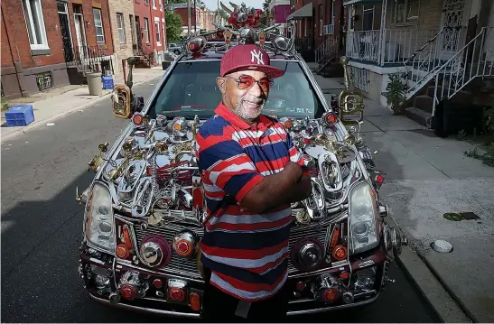  ?? Tim Tai/The Philadelph­ia Inquirer/TNS ?? Gilbert Hilton stands for a portrait by one of his two art cars on July 9 in North Philadelph­ia. Hilton searches for baubles at Goodwill stores to attach to his vehicles as decor.