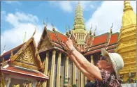  ?? MENG ZHONGDE / FOR CHINA DAILY ?? A tourist enjoys the sights in Bangkok, Thailand. More Chinese travelers prefer individual­ized travel.