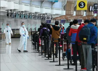  ?? (AP/The Canadian Press/Nathan Denette) ?? People line up Wednesday to board an internatio­nal flight at Pearson Internatio­nal Airport in Toronto. Canadian Prime Minister Justin Trudeau closed Canada’s internatio­nal borders to nonessenti­al travel in March.