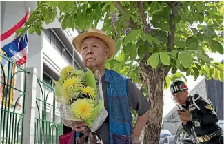  ?? PHOTO: AP ?? Sulak Sivaraksa pauses outside a military court in Bangkok as he enters to find out whether Thailand’s military prosecutor has proceeded with the indictment against him on a lese-majeste charge.