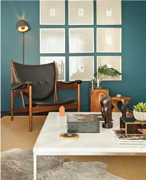 ??  ?? Le mur d'accent bleu sarcelle découpe parfaiteme­nt l'espace de la pièce. Les occupants, confortabl­ement installés dans le fauteuil de cuir rappelant la chaise Safari – relique des années 60 – s'évaderont sans mal à la lecture d'un bon livre.