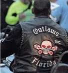  ?? FRANK FERNANDEZ/DAYTONA BEACH NEWS-JOURNAL ?? A man wearing an Outlaws Motorcycle Club vest rides down Main Street on March 2 during Bike Week in Daytona Beach.