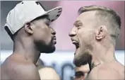  ?? John Locher Associated Press ?? FLOYD MAYWEATHER JR., left, and Conor McGregor face off at the weigh-in for tonight’s fight.