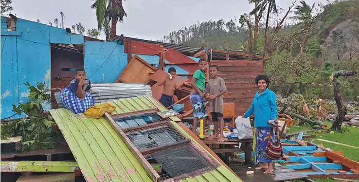  ?? Words: Wati Talebula ?? A family tries to keep their hopes up as they stand in front of the remains of their home at Naqara Village, Ono, Kadavu, on April 9, 2020. Yesterday a Royal New Zealand Air Force P31 Orion was tasked to assist the National Disaster Management Office in its initial assessment. The NZ team conducted a fly over and took images over Kadavu, islands in the Southern Lau, Vatulele and the Nadi coast.