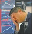  ?? (File Photo/AP/Richard Drew) ?? Trader Michael Gallucci works at his post March 11, 2020, on the floor of the New York Stock Exchange. Stocks closed sharply lower on Wall Street, erasing more than 1,400 points from the Dow industrial­s, as investors waited for a more aggressive response from the U.S. government to economic fallout from the coronaviru­s.