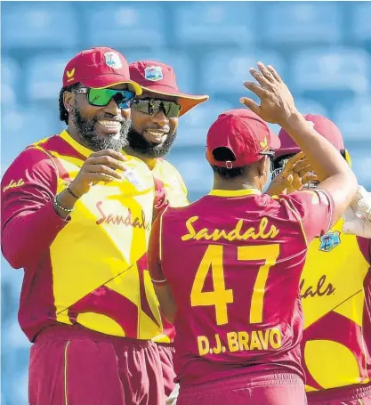  ?? CWI PHOTO ?? West Indies players celebrate the fall of a South African wicket during a T20 Internatio­nal match played in Grenada in August.